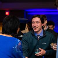 A grad smiles shaking President Mantella's hand